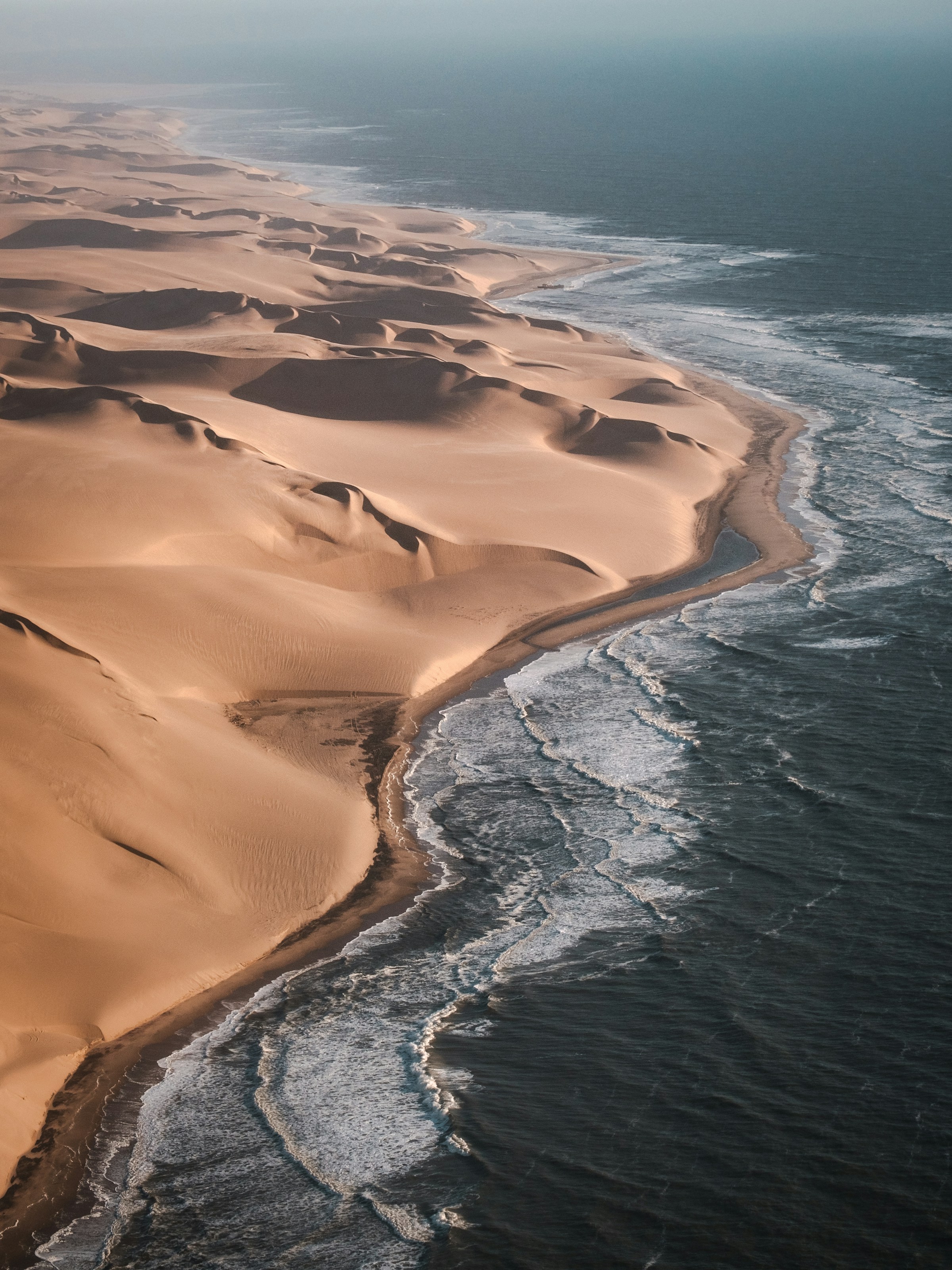 Golden Namib dunes meeting the Atlantic Ocean